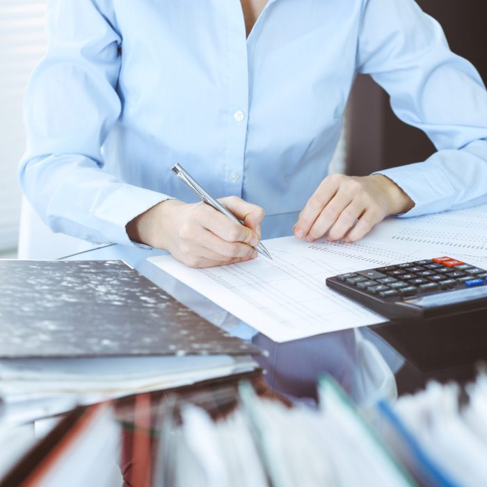 Bookkeeper woman or financial inspector making report, calculating or checking balance, close-up. Business, audit or tax concepts.