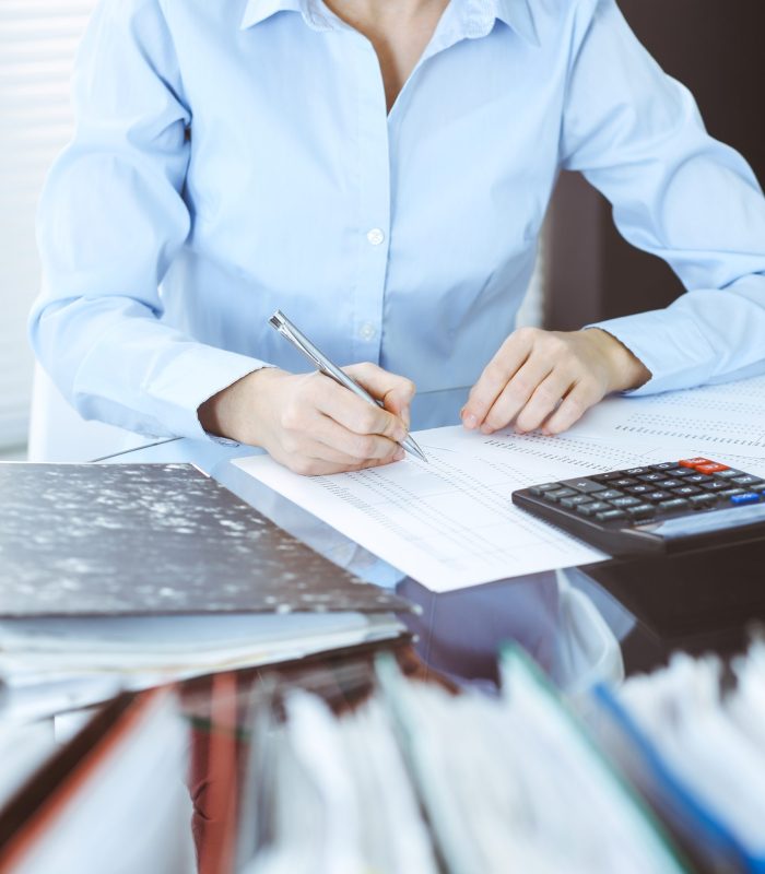 Bookkeeper woman or financial inspector making report, calculating or checking balance, close-up. Business, audit or tax concepts.